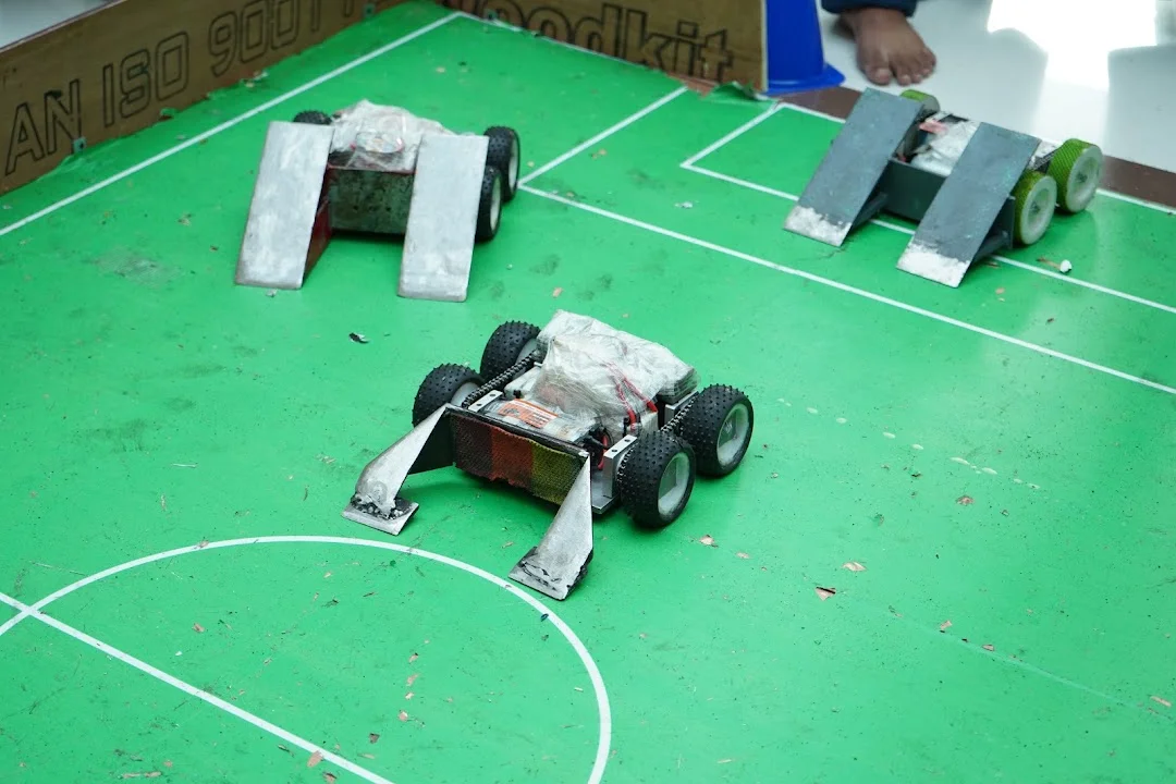 Close-up of custom soccer robot chassis and ball guides at RGI 2026