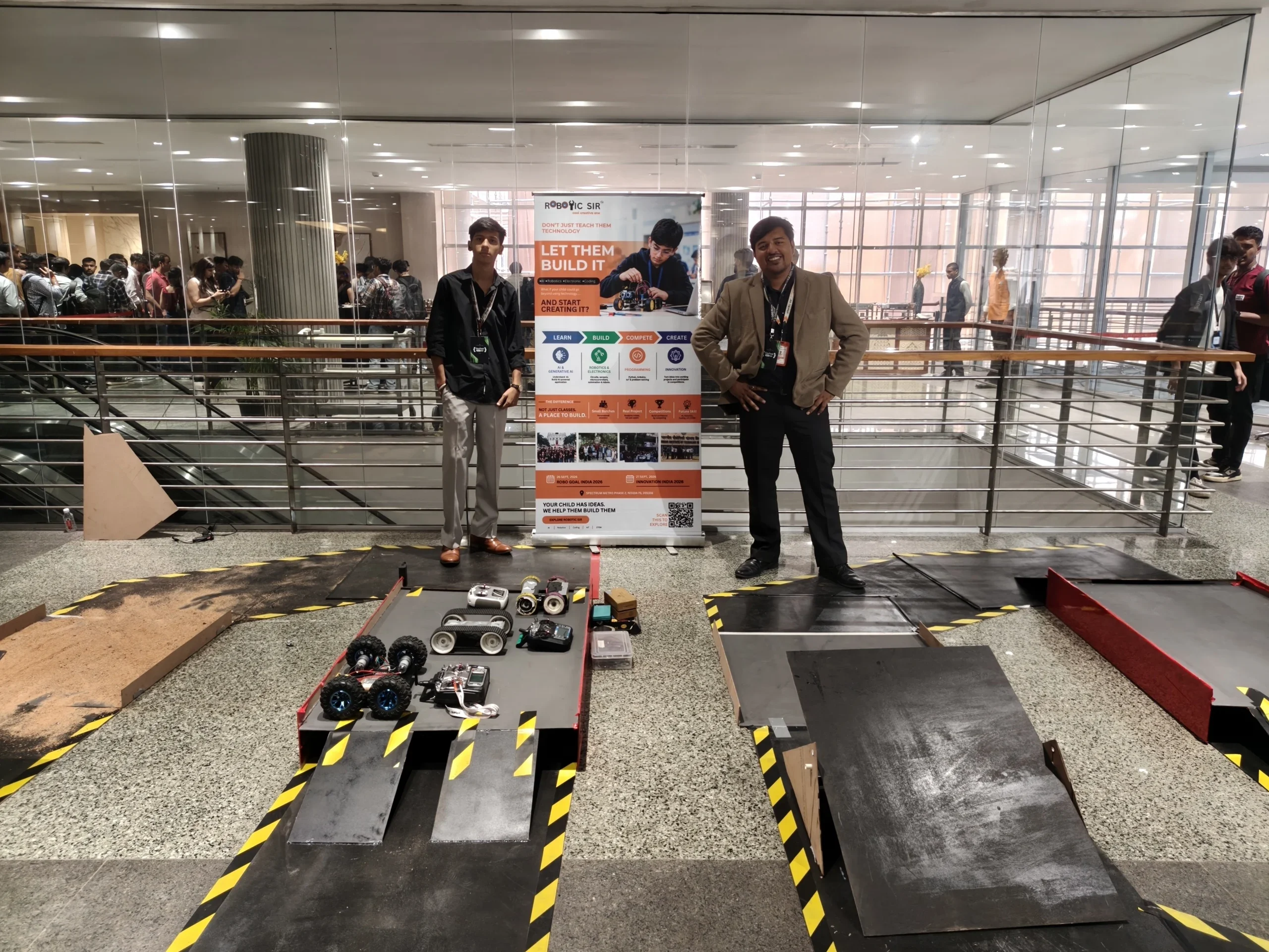 Robo Race obstacle course with ramps, hazard-striped tracks and student-built robots