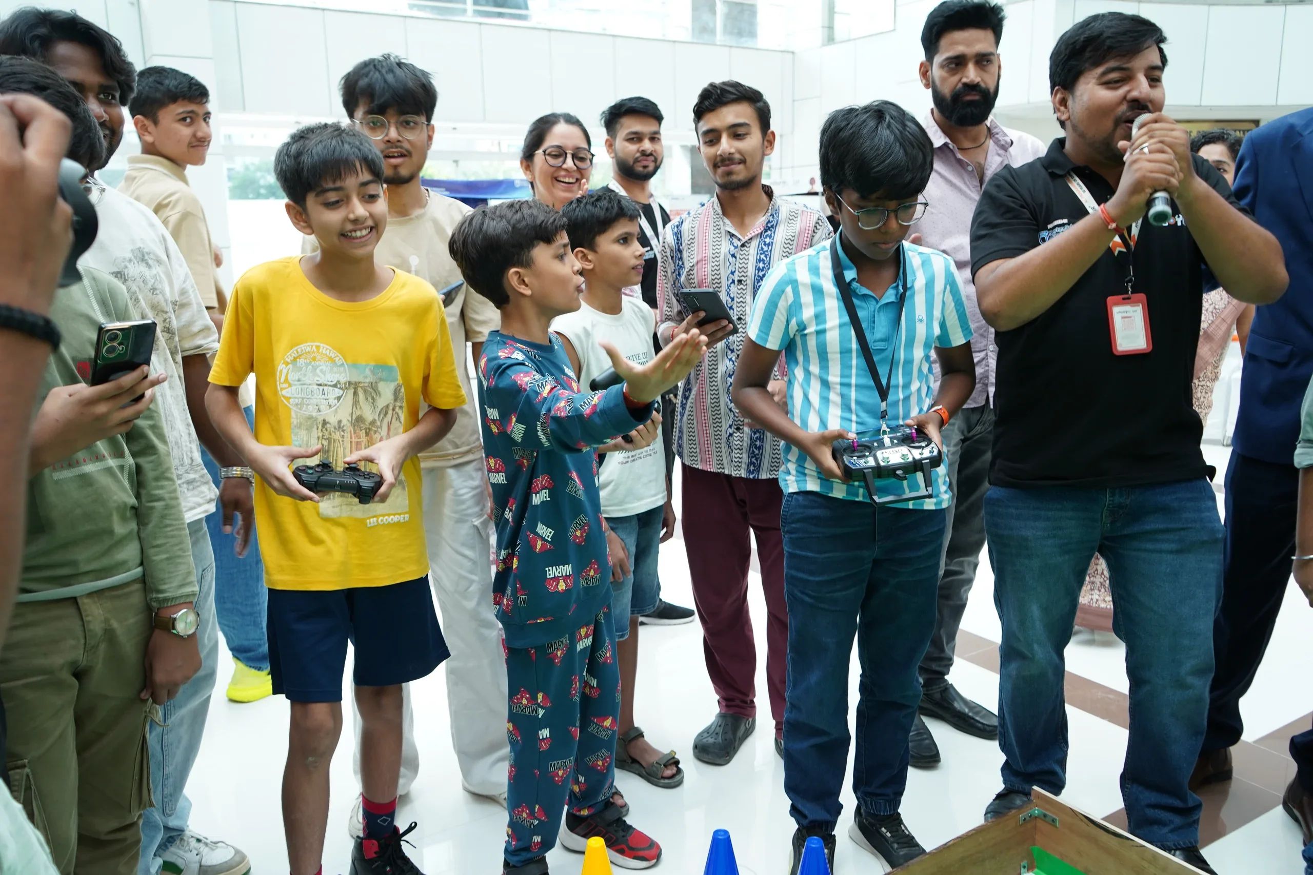 Young RGI competitors holding controllers beside the soccer arena
